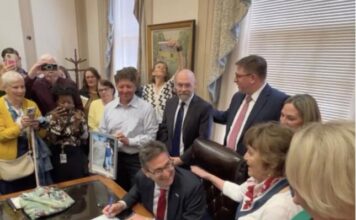 Governor Meyer signs the Ron Silverio/Heather Block Delaware End-of-Life Options Act into law surrounded by advocates and legislative champions on May 20.