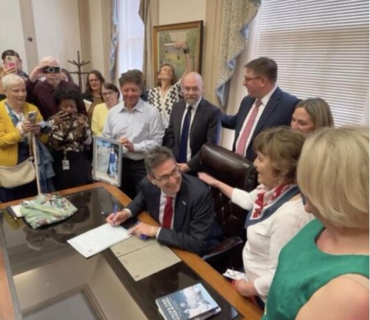 Governor Meyer signs the Ron Silverio/Heather Block Delaware End-of-Life Options Act into law surrounded by advocates and legislative champions on May 20.